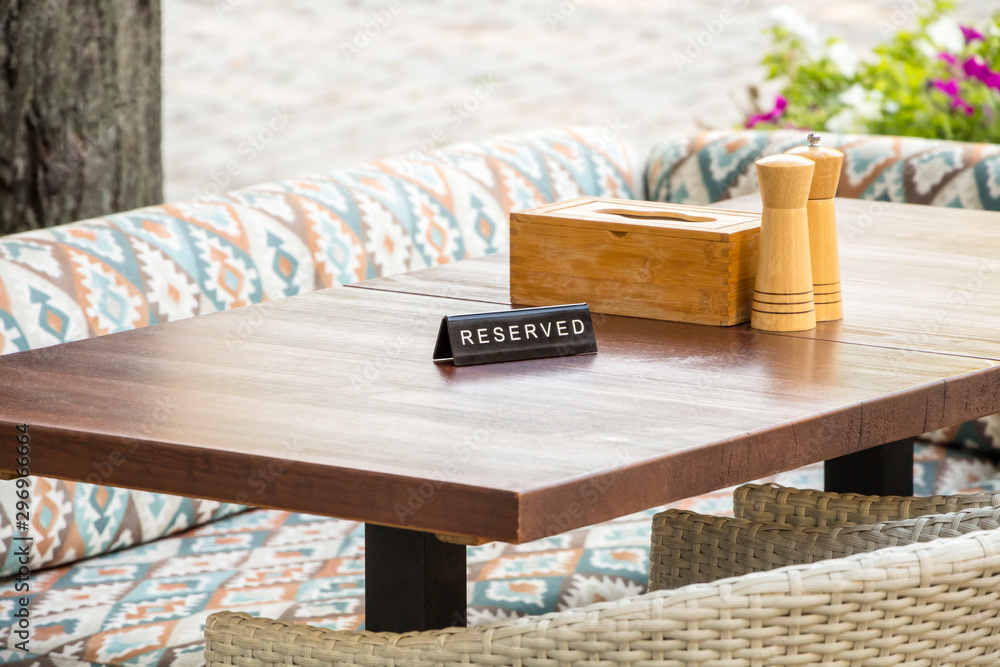 Φωτογραφία a reserved sign on a wooden table in an outdoor cafe, against a background of cu