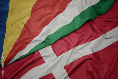 waving colorful flag of denmark and national flag of seychelles.