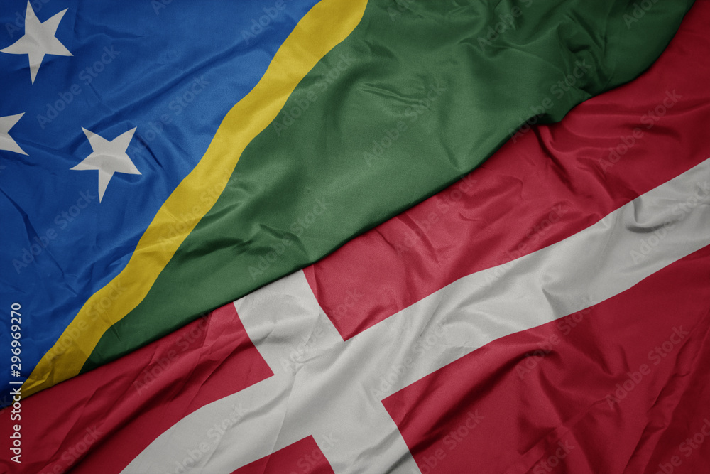 waving colorful flag of denmark and national flag of Solomon Islands .