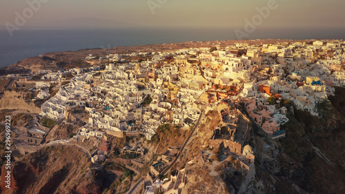 Aerial drone photo of world famous beautiful sunset at traditional and picturesque village of Oia with golden colours, Santorini island, Cyclades, Greece