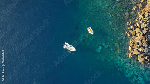 Aerial top down photo of fishing boat in small port of Ammoudi, Santorini island, Cyclades, Greece © aerial-drone