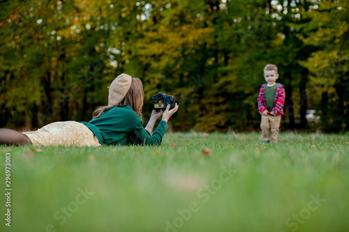 Woman photographer photographing the child to spend outside in the park