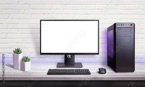Gaming PC on white desk. Isolated screen for mockup. Brick wall in background.