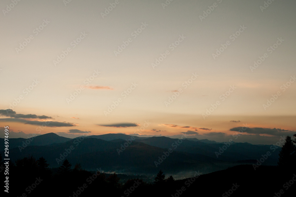 Sunset over the mountains in Ukraine, raising sun beams illuminating an mountainside