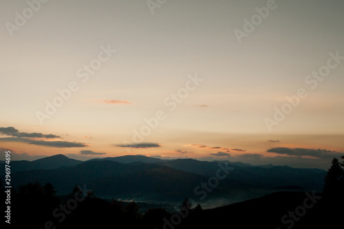 Sunset over the mountains in Ukraine, raising sun beams illuminating an mountainside © volody10