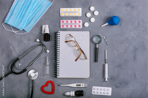 Medicine instruments, tablets and other medicines on a grey background. Top view.