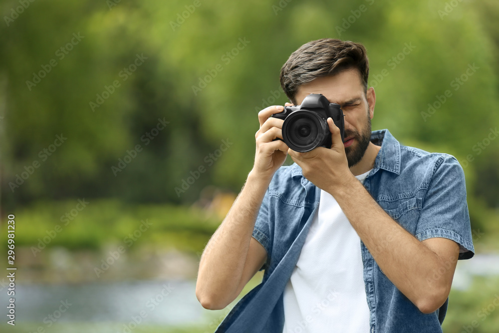 Photographer taking photo with professional camera in park Photographer taking photo with professional camera in park