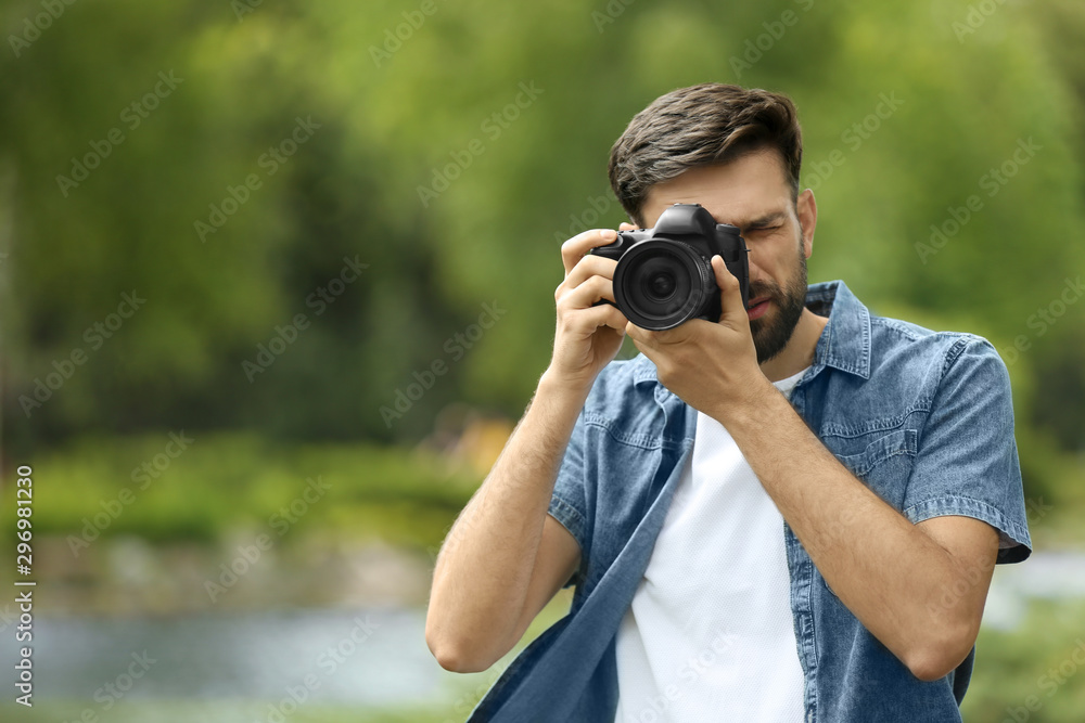 Photographer taking photo with professional camera in park