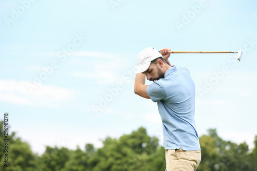 Man playing golf against blue sky. Space for text