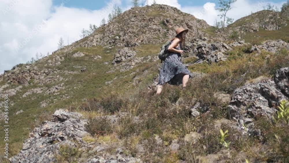 Attractive brunette girl in a hat with a backpack travels in the mountains Attractive brunette girl in a hat with a backpack travels in the mountains