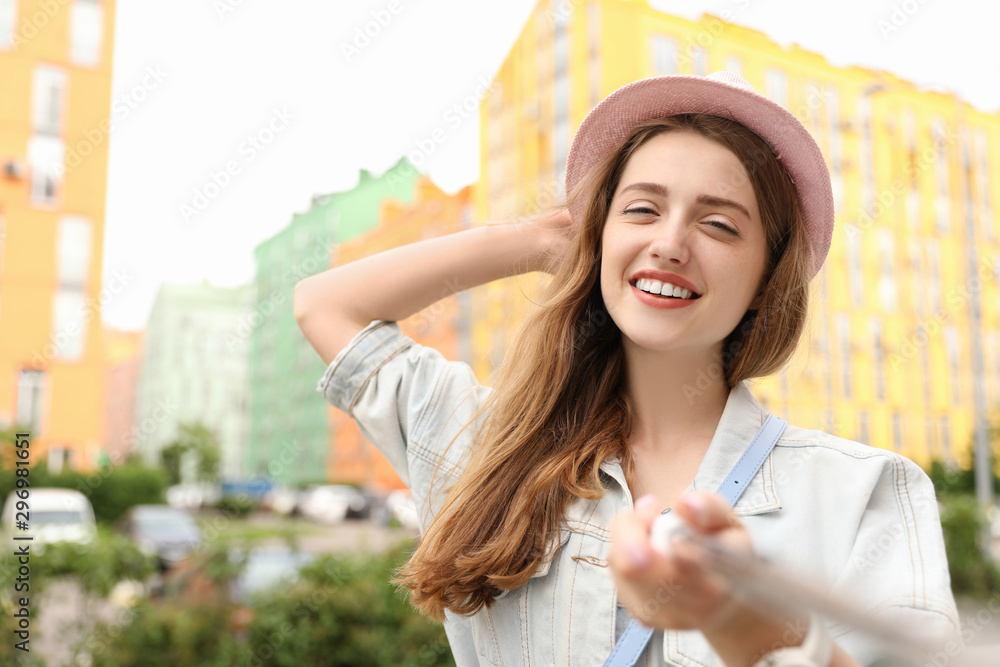 Beautiful young woman in stylish hat taking selfie outdoors Beautiful young woman in stylish hat taking selfie outdoors