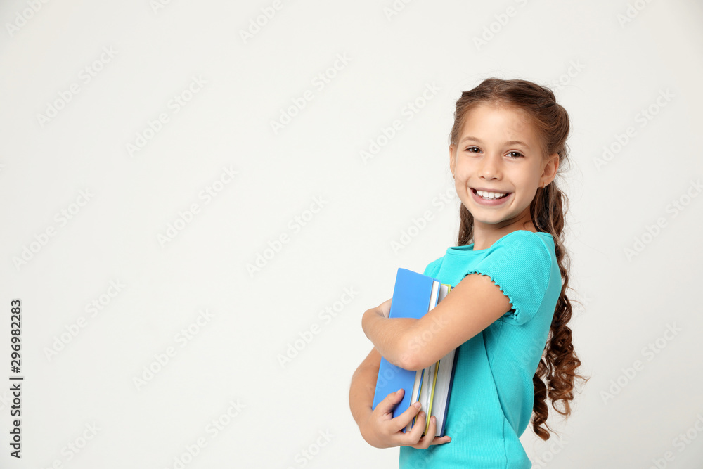 Portrait of cute little girl with books on grey background, space for text. Reading concept Portrait of cute little girl with books on grey background, space for text. Reading concept