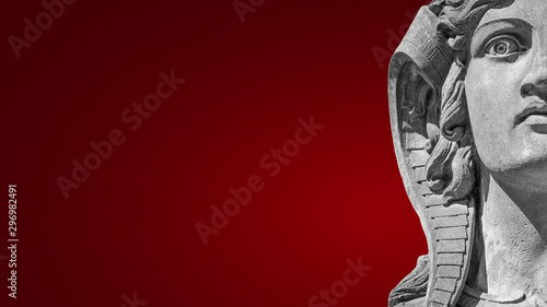 Face of beautiful female sphinx isolated at smooth red background with paste space © neurobite