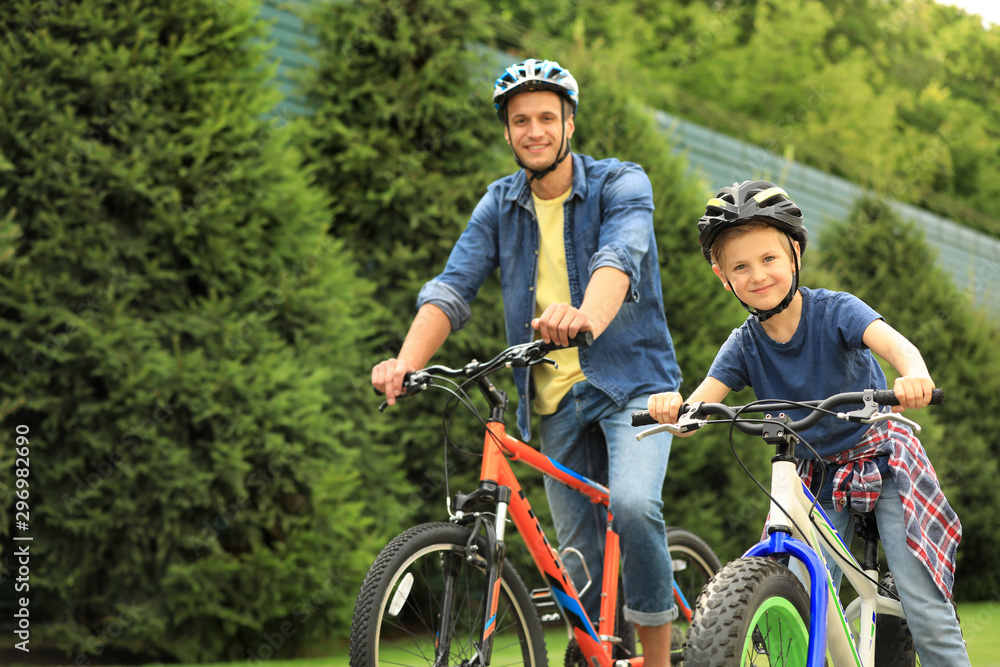 Dad and son riding modern bicycles outdoors