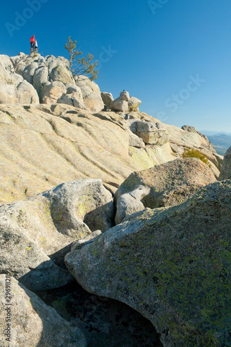 People at the geodetic vertex of the summit of a granite mountain.