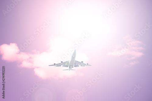 Airliner against the sky with clouds. The sun shines brightly.