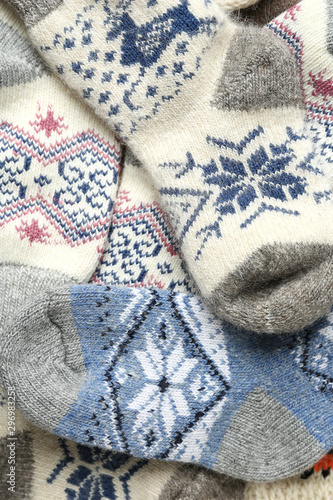 Different knitted woolen socks as background, closeup