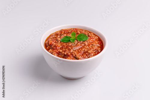 Bolognese (also know as Bolognesa or Bolonhesa) sauce in a white bowl isolated in white background, soft light, studio photo, copy space