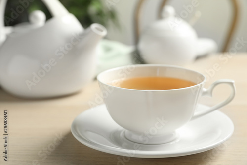 Cup of hot green tea on wooden table indoors