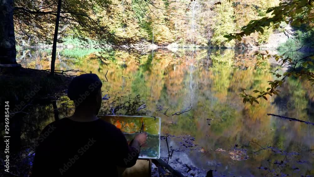 Painter paints by the lake in autumn. 4K Painter paints by the lake in autumn. 4K