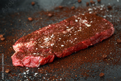 Ready to cook seasoned with home made coffee rub beef steak on dark background