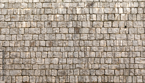 Texture of unshaped brown stone wall pattern, made of rocks photo