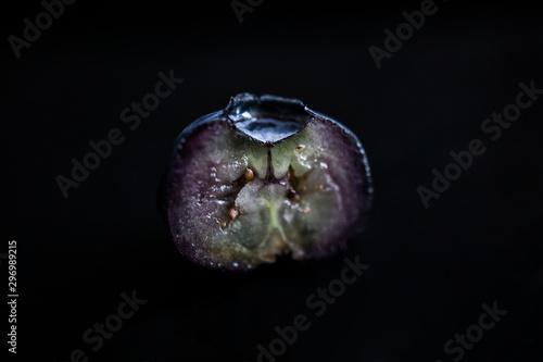 Foto Cross section of a ripe american blueberry fruit against dark background
