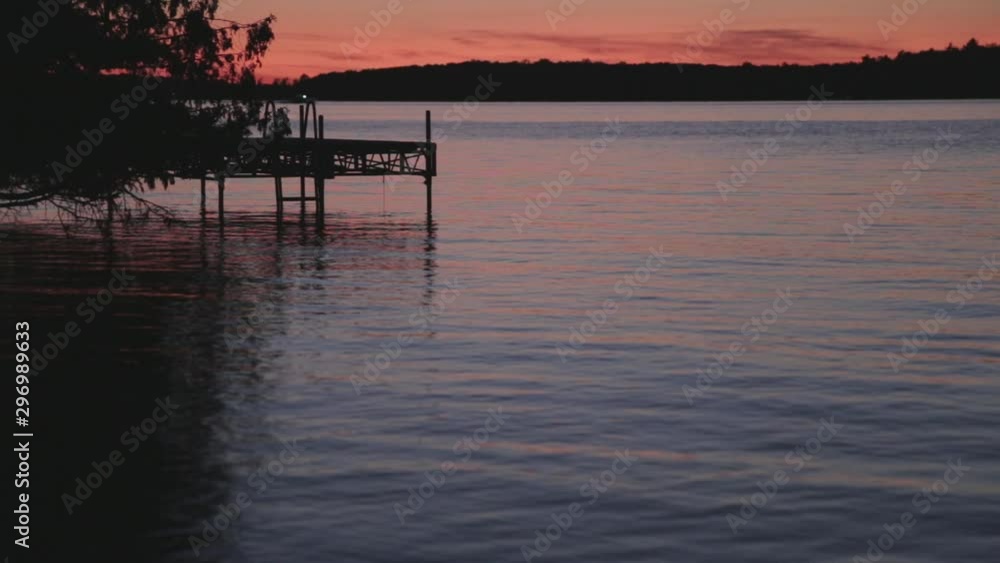Beautiful view of lake during sunset. Water is calm and peaceful. View of boat in the background. Beautiful view of lake during sunset. Water is calm and peaceful. View of boat in the background.