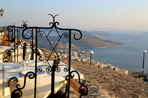 Romantic interior in the top roof restaurant in Saranda in Albania. Panoramic view from Lecursi castle.