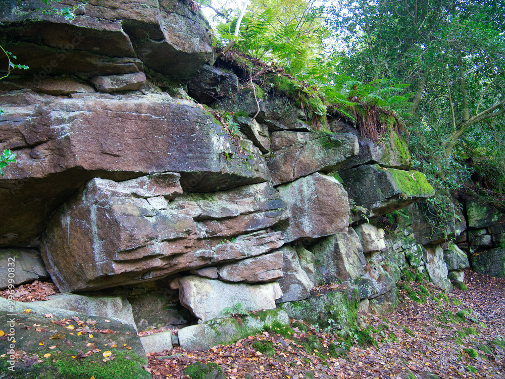 Fractured sandstone next to the River Wharfe in the Yorkshire Dales, UK - sandstone of the Pendleian Age in the Millstone Grit Group - sedimentary bedrock formed in the Carboniferous Period. Fractured sandstone next to the River Wharfe in the Yorkshire Dales, UK - sandstone of the Pendleian Age in the Millstone Grit Group - sedimentary bedrock formed in the Carboniferous Period.