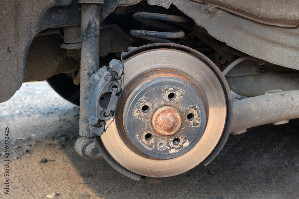 Car without wheels. Disc brake of the car for repair. Worn out brake system. Car without wheels. Disc brake of the car for repair. Worn out brake system.