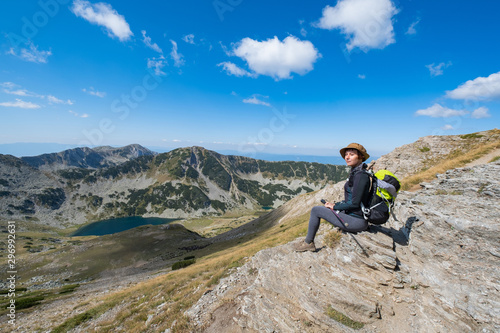 Young woman traveler in the bulgarian mountains , hiking in the sunny day