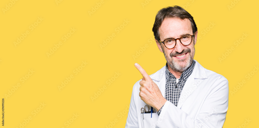 © Krakenimages.com - Middle age doctor men wearing medical coat cheerful with a smile of face pointing with hand and finger up to the side with happy and natural expression on face