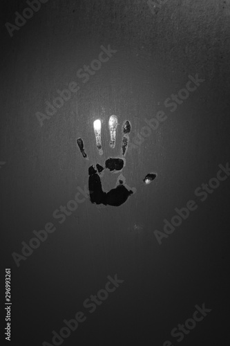a black - and-white handprint on the fogged window