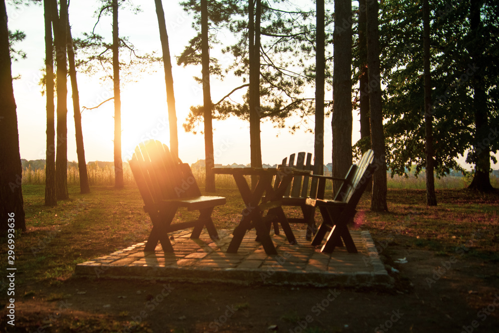 Sunset in the park, benches and the wooden table sunlit