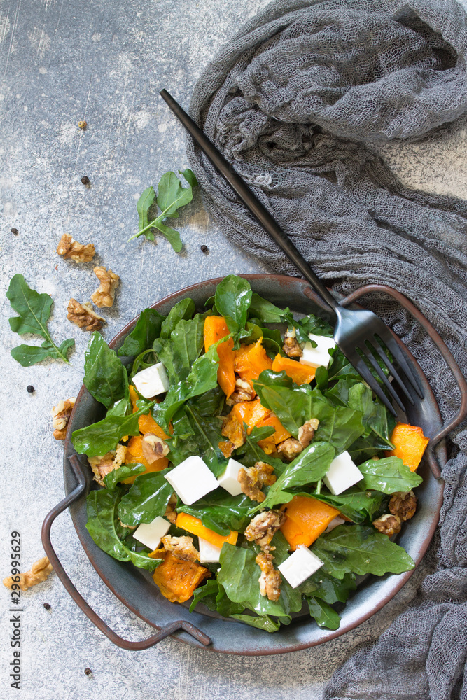 Concept diet menu, Vegan food. Salad with baked pumpkin, feta, cheese and vinaigrette dressing on stone background. Top view flat lay.