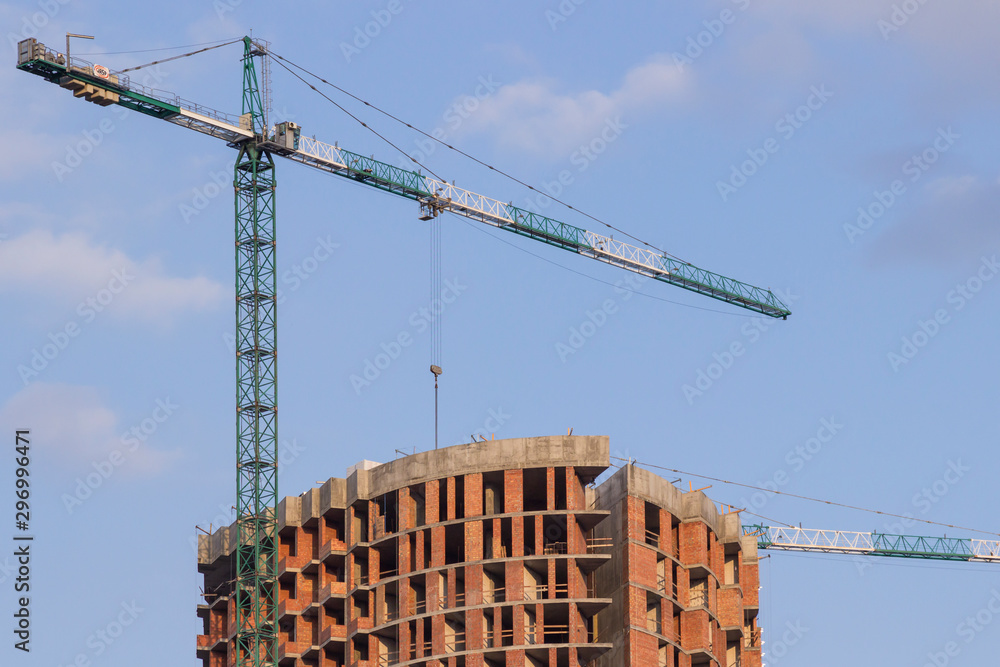 High construction cranes at a construction site.