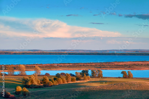 Landscape and Baltic Sea on Hiddensee island at sunset in Autumn. Romantic evening view from the hill towards shallow sea and coast of Rugen island.