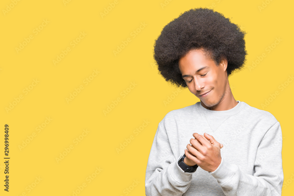 Young african american man with afro hair wearing sporty sweatshirt Suffering pain on hands and fingers, arthritis inflammation Young african american man with afro hair wearing sporty sweatshirt Suffering pain on hands and fingers, arthritis inflammation