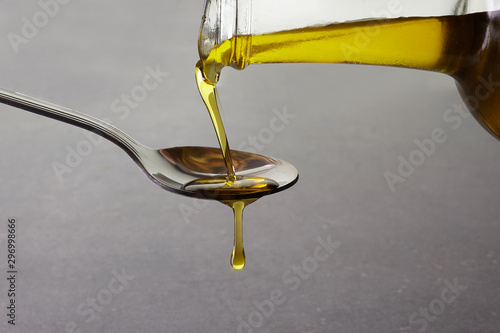 Obraz na plátně pouring olive oil from glass bottle on grey background