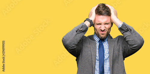Fotografie Handsome business man wearing suit and tie suffering from headache desperate and stressed because pain and migraine