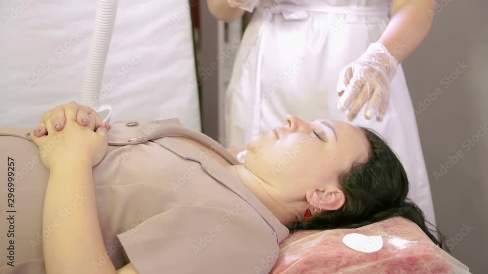 The beautician makes the correction of the eyebrows of the client sugar paste. The beautician makes the correction of the eyebrows of the client sugar paste.