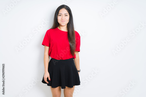 Fotografija Beautiful brunette woman wearing red t-shirt and skirt over isolated background puffing cheeks with funny face