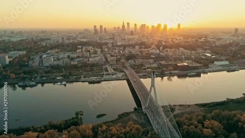 Establishing Aerial Panoramic Shot of Warsaw Cityscape, capital of Poland. Swietokrzyski Suspension Bridge and Urban Downtown Skyline at Sunset. 4K Push in Background Drone Bird's-eye view Video