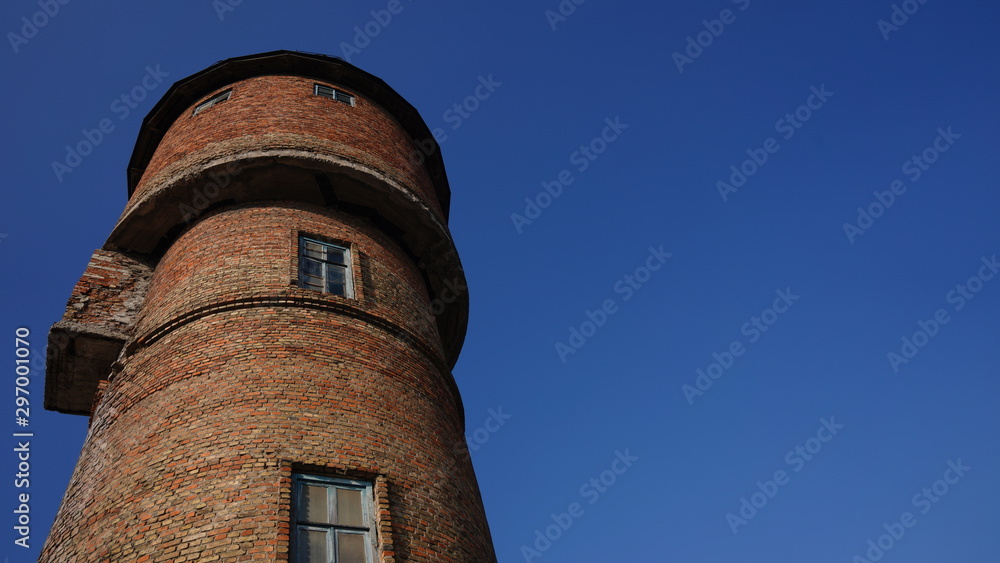 Red brick water tower against blue sky