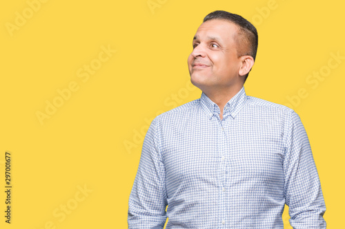 Middle age arab business man over isolated background smiling looking side and staring away thinking.