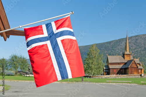 Norwegian flag and wooden church Lomskyrkja in Lom, one of the biggest stave churches in Norway dates back to 1158-59. photo