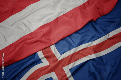 waving colorful flag of iceland and national flag of austria.