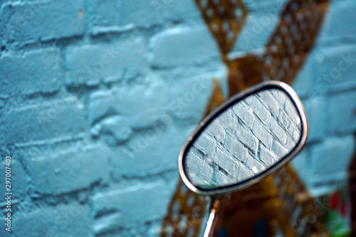 Bike mirror against a blue brickstone wall photo