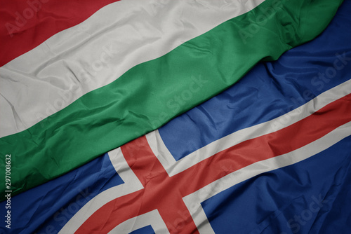 waving colorful flag of iceland and national flag of hungary.